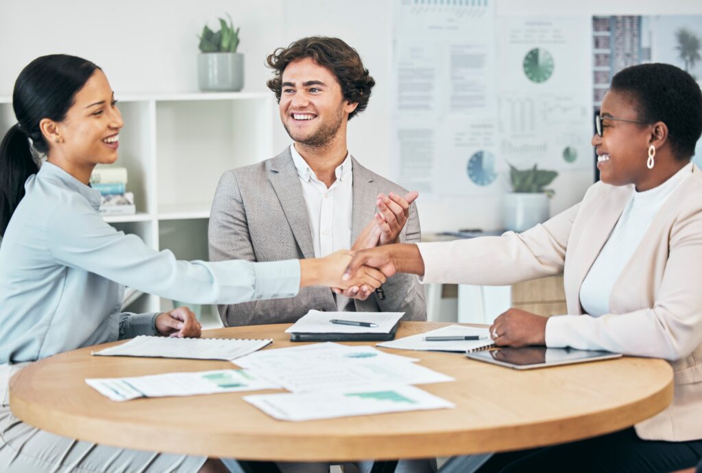 Professionals discussing customer acquisition strategies while celebrating a successful client agreement.